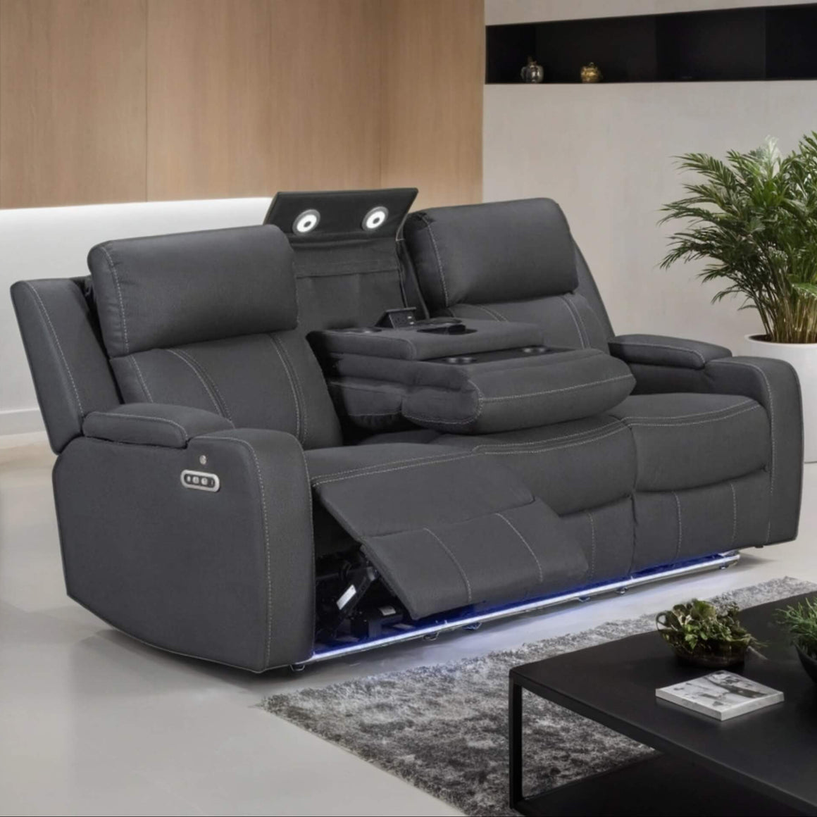 Gray recliner sofa in a modern living room setting with a coffee table and plants.