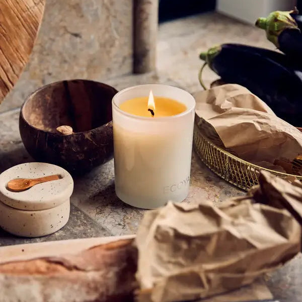 Candle burning on a stone surface with natural elements
