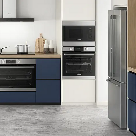 Modern kitchen with blue cabinets, stainless steel appliances, and a gray floor.