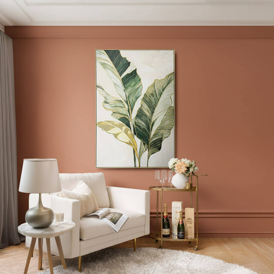 Living room with a large framed leaf print on the wall, a sofa, lamp, and small table with decorative items.