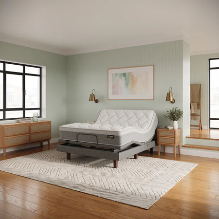 Mattress on a stand in a bedroom with wooden flooring and light green walls.