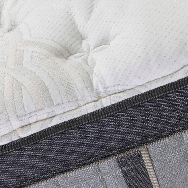 Close-up of a mattress with a textured surface and visible stitching details.