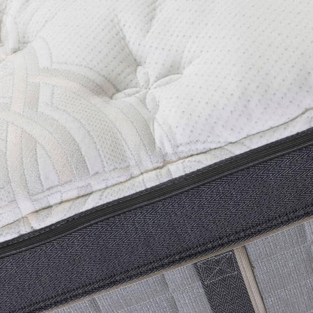 Close-up of a mattress with a textured surface and visible stitching details.