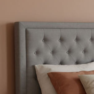 Bedroom with a gray upholstered bed and brown bedding