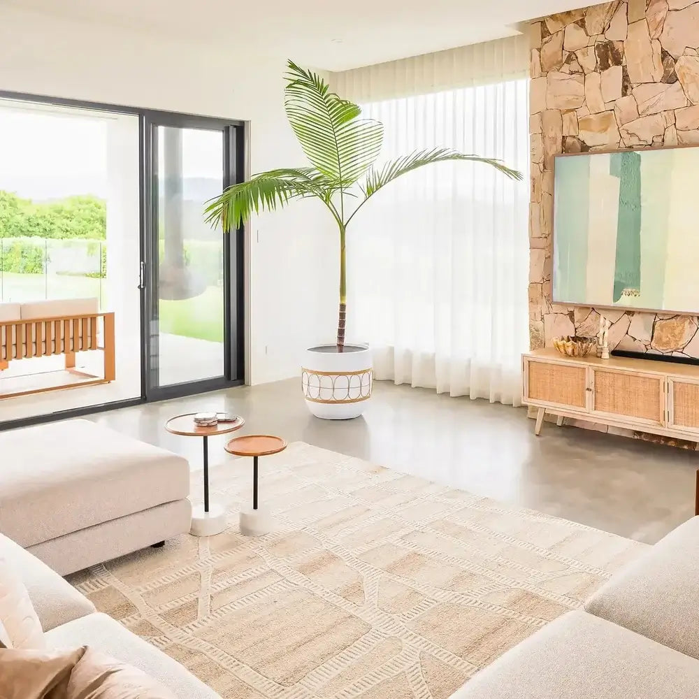 Modern living room with a stone wall, TV, and a large window.