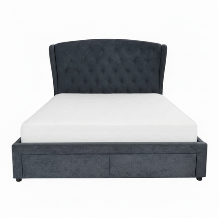 Gray upholstered bed with light blue diamond patterned comforter and pillows on a white background