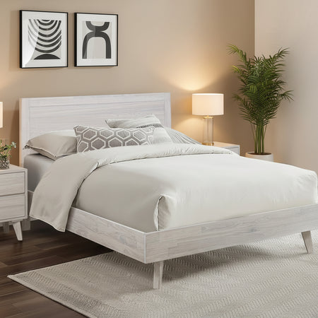 Neatly made bed with white bedding in a modern bedroom setting.
