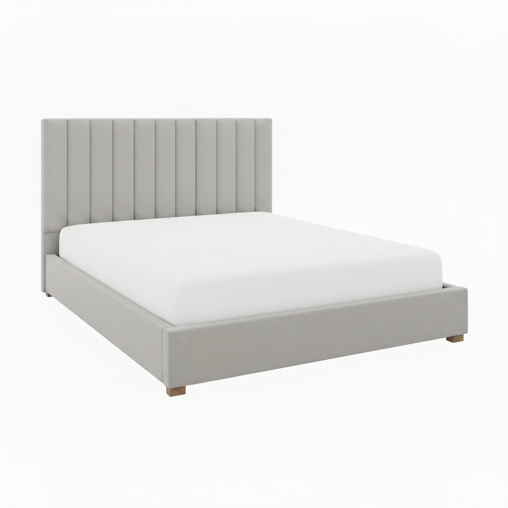 Gray upholstered bed with white bedding and decorative pillows in a bedroom setting.