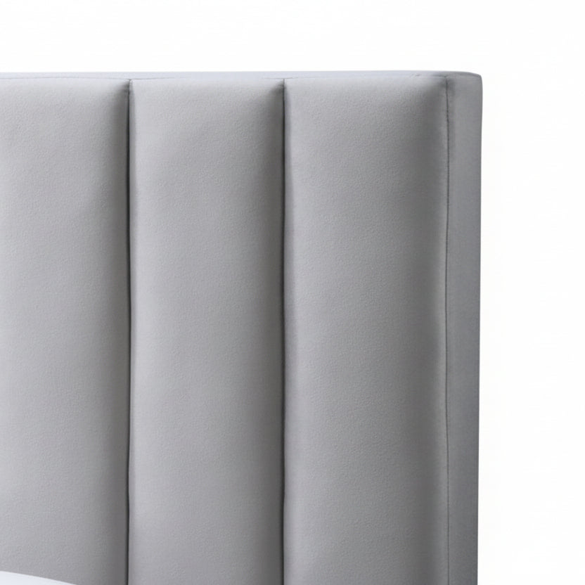 Gray upholstered headboard with tufted design against a white wall